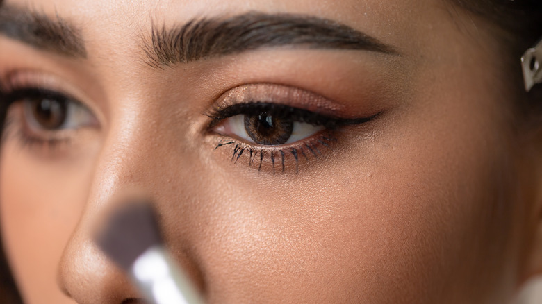Closeup of person applying contour on nose