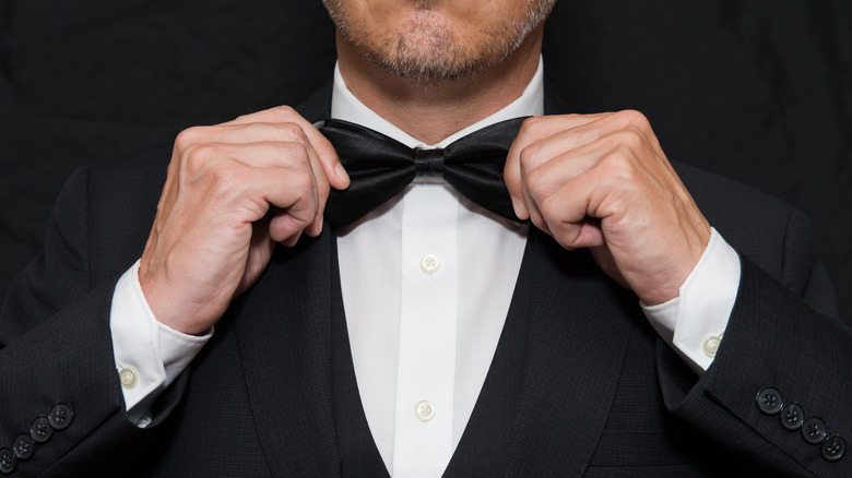 man straightening Black bow tie