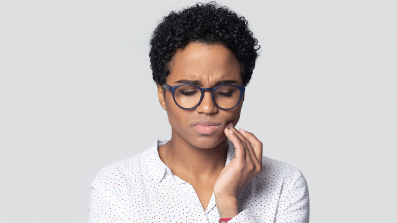 Woman holding her jaw in pain