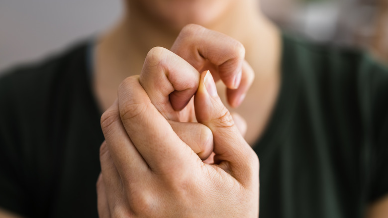 Woman cracking her finger joints