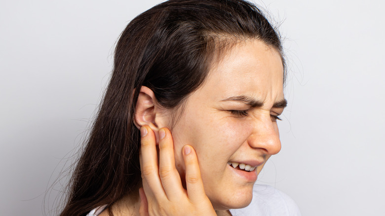 Woman touching her ear 