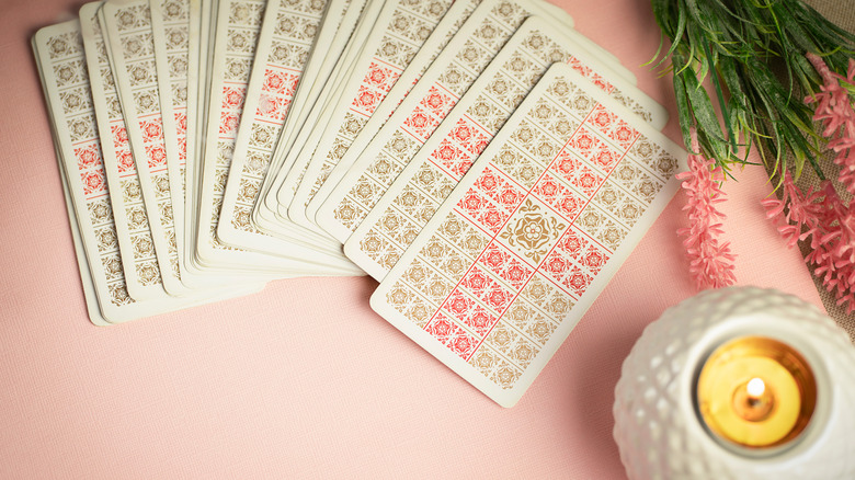 Pink tarot card spread with a candle