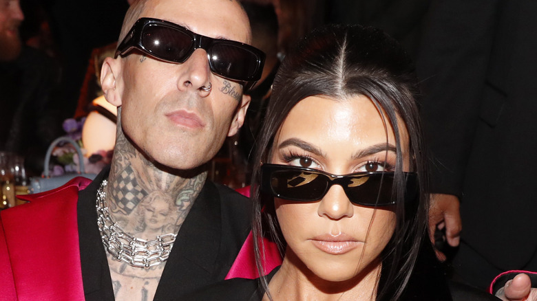 Travis Barker and Kourtney Kardashian wearing sunglasses