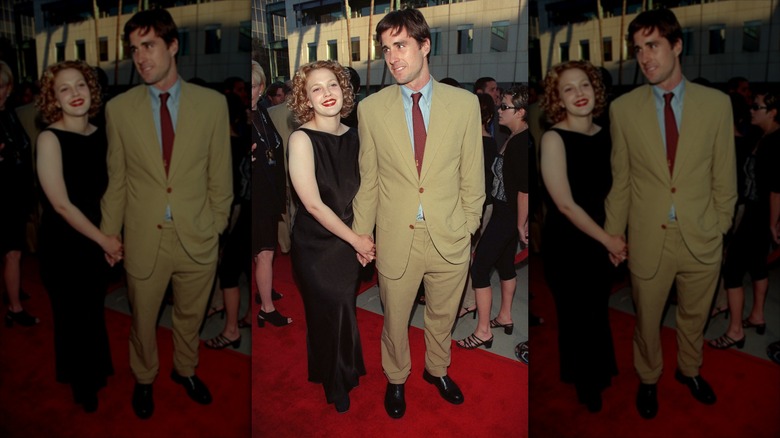 Drew Barrymore and Luke Wilson holding hands on a red carpet in 1999