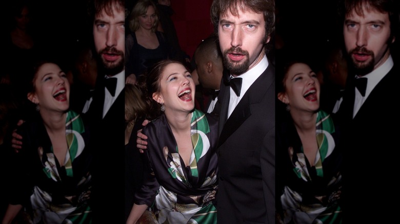 Drew Barrymore looking up at Tom Green making a goofy face and laughing