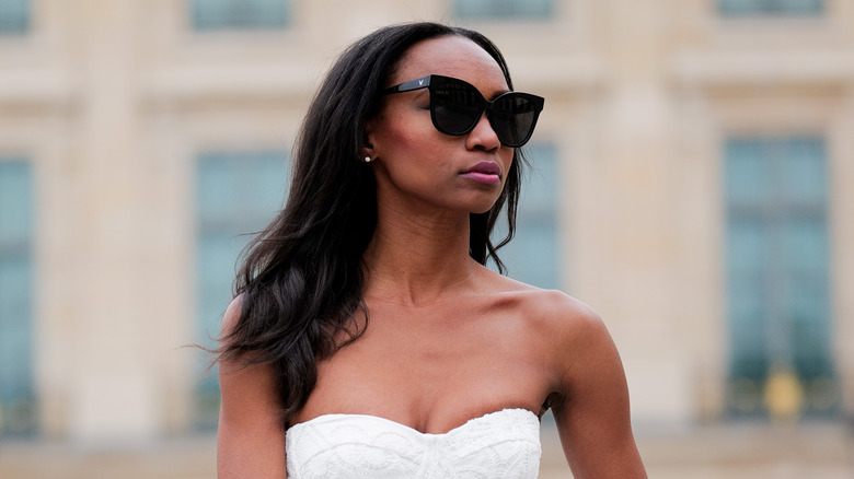 Woman with dark cat eye glasses and long wavy hair