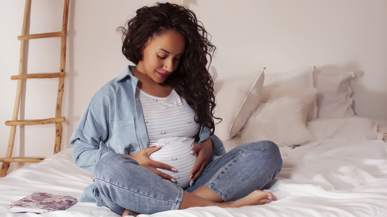 Pregnant woman cradling her belly