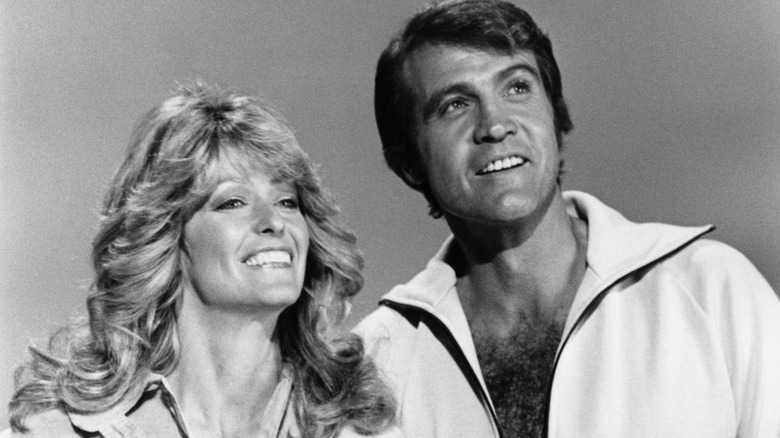 Farrah Fawcett and Lee Majors posing together in a promo photo in 1977