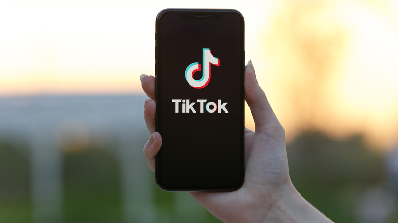 Person holding up phone displaying TikTok