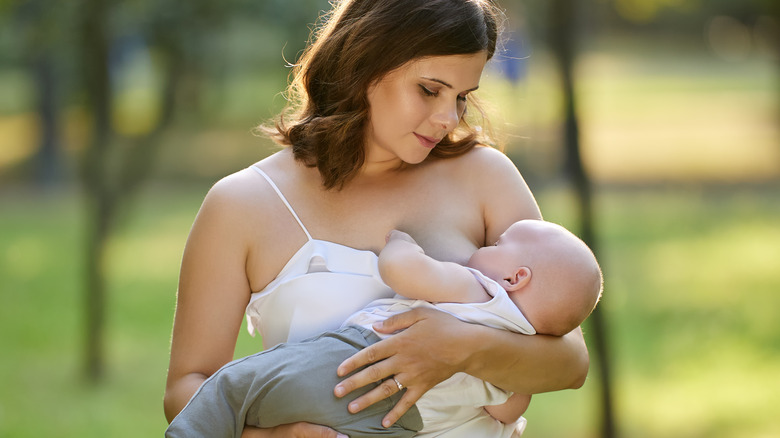 woman breastfeeding baby outside