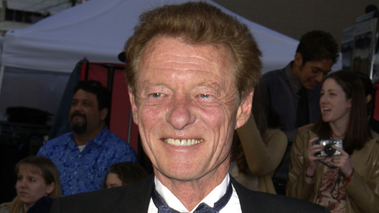 Ken Osmond smiling while posing at an event in a tuxedo