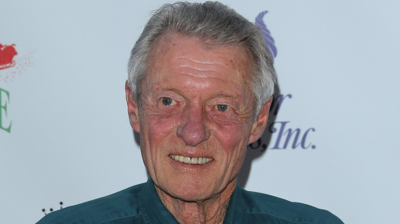 Ken Osmond smiling while posing at an event