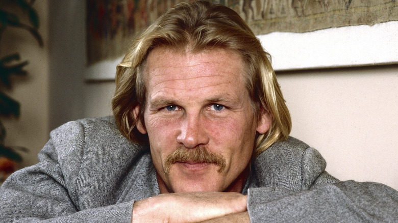 Nick Nolte smiling resting his chin on his hands