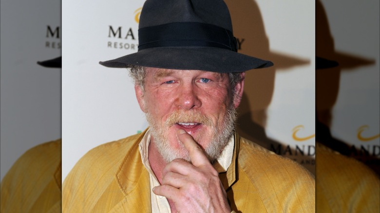 Nick Nolte wearing a fedora and bright yellow trench coat
