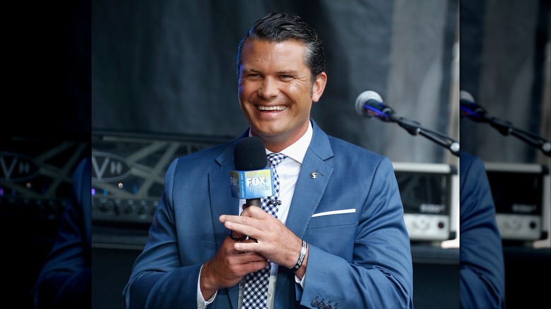 Pete Hegseth holds a Fox & Friends mic in 2018