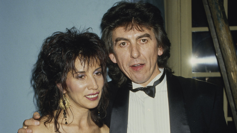 Olivia and George Harrison smiling while posing together in their finery