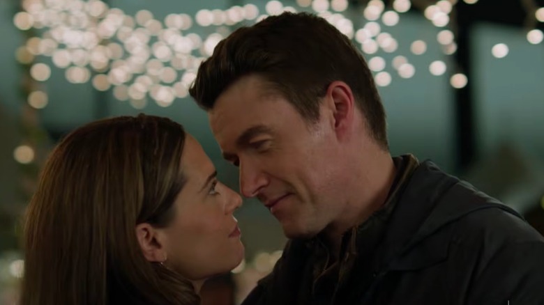Avery (Lyndsy Fonseca) and Matt (Robert Buckley) lean into each other in Holiday Touchdown: A Bears Love Story