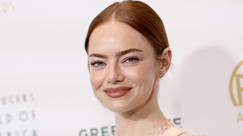 image of Emma Stone with an enigmatic smile on the red carpet of an event