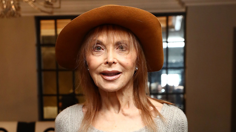 "Gilligan's Island" actor Tina Louise smiles wearing a brown hat inside