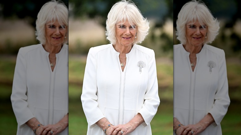 Queen Camilla smiling in white dress
