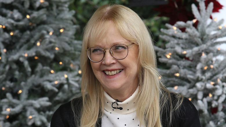 Shelley Long smiling while wearing glasses