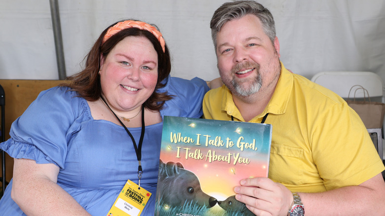 Chrissy Metz and Bradley Collins smiling with a book they created together.
