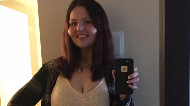 Christina Phillips smiles in a mirror selfie showing off her transformation