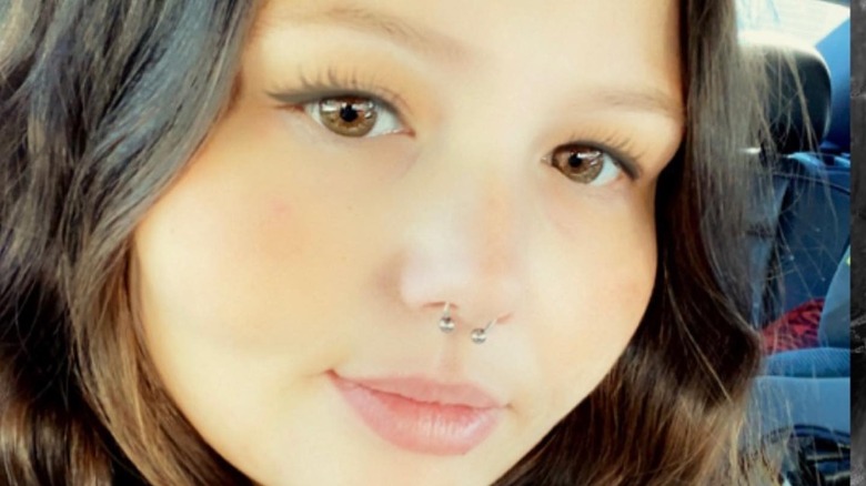 Christina Hall smiles in a selfie in golden light with her makeup done.