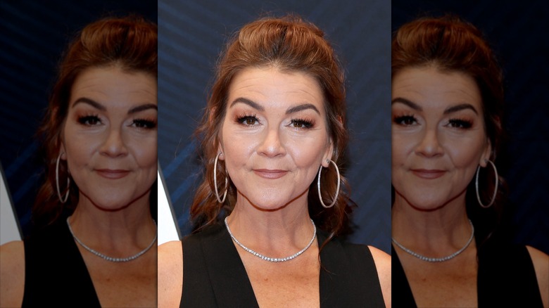Gretchen Wilson on a red carpet in big hoop earrings and a diamond necklace