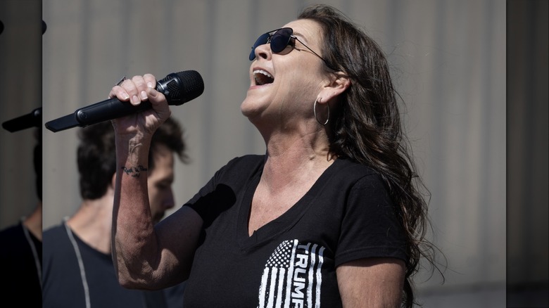 Gretchen Wilson singing in sunglasses and a Trump shirt