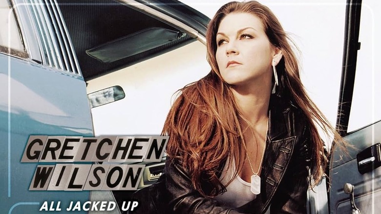 The cover for Gretchen Wilson's album All Jacked Up, featuring her sitting in the open passenger side of a blue car