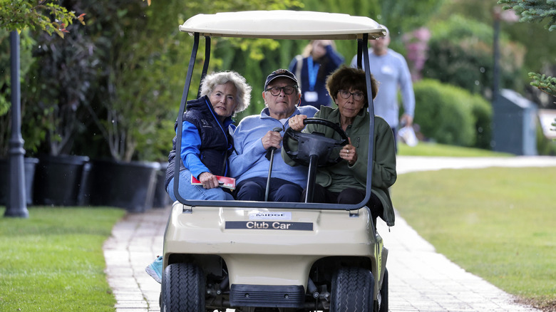 Tom Brokaw in a golf cart