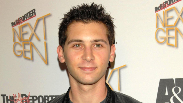 Closeup of Justin Berfield smiling against step-and-repeat