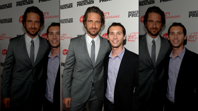 Gerard Butler and Justin Berfield smiling at Machine Gun Preacher step-and-repeat