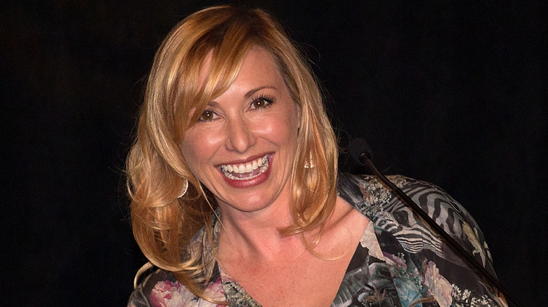 Closeup of Kari Byron smiling in front of mic
