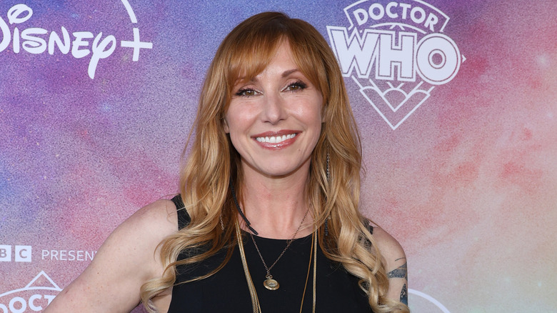 Kari Byron smiling on step-and-repeat for the Disney+ premiere of 