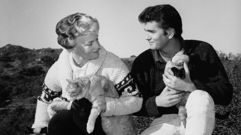 Dodie Levy-Fraser and Michael Landon circa 1960 posing together for a photo while holding cats