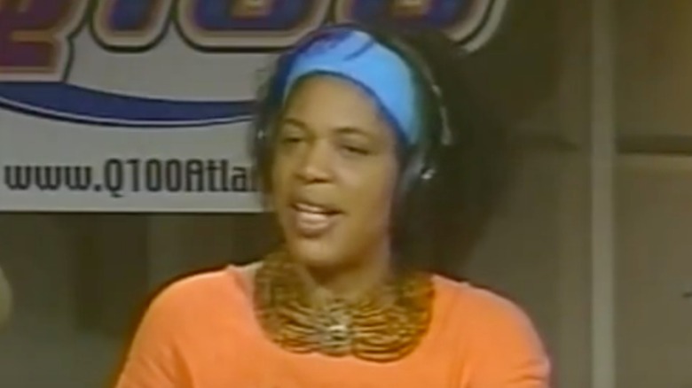 Miss Cleo speaking into a microphone at a radio station