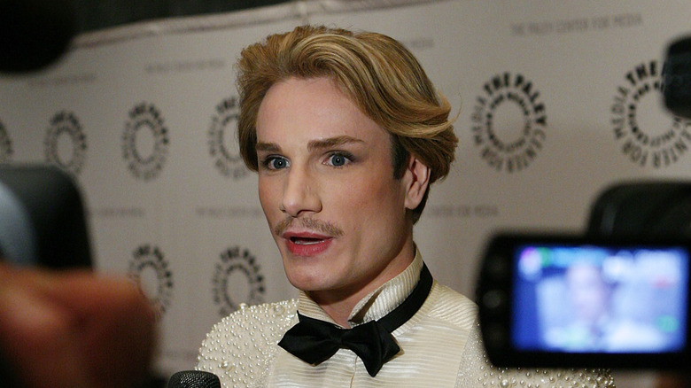 Austin Scarlett speaking before a throng of cameras on a red carpet in 2012.