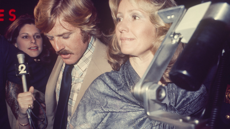 Robert Redford and Lola Van Wagenen surrounded by press