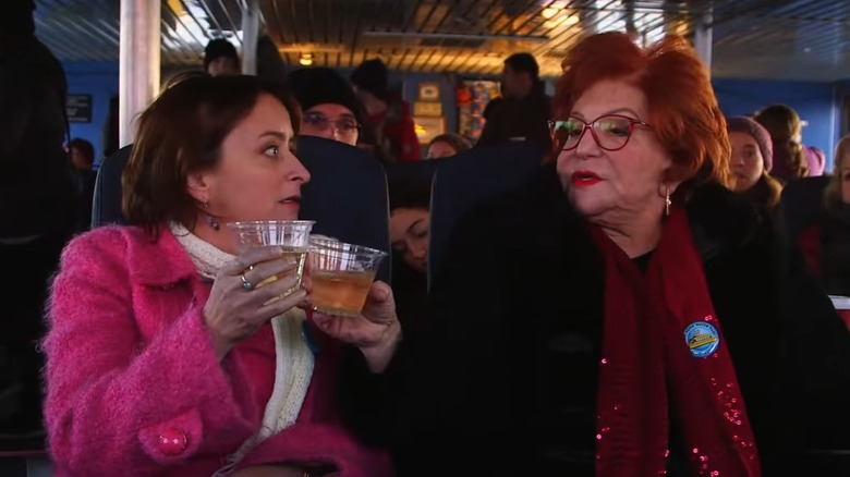 Sally Jessy Raphael and Rachel Dratch clinking glasses on a ferry
