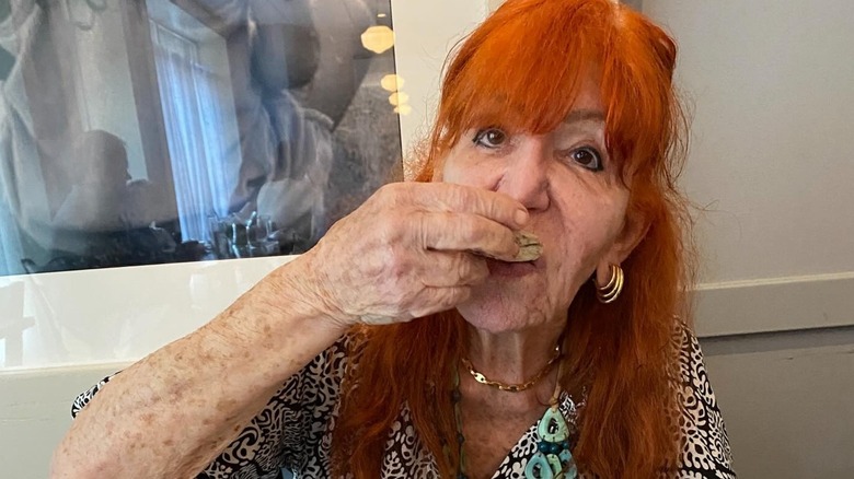 Sally Jessy Raphael with no glasses eating an oyster