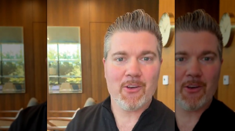 Beau Wirick with gray hair sits at a desk in a room with wood walls