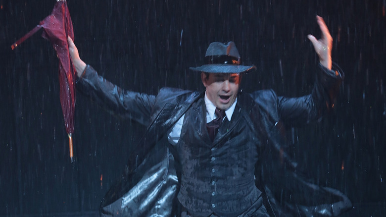 Adam Garcia dancing onstage in Singin' in the Rain with water and a black background