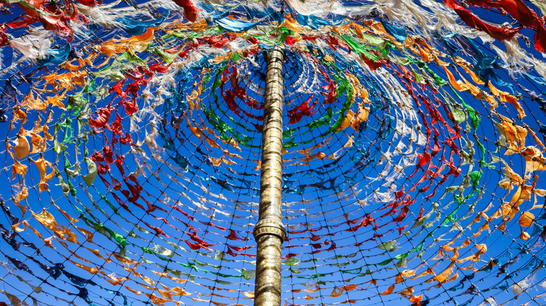 Colorful Tibetan prayer flags and a pole in a mountainous region