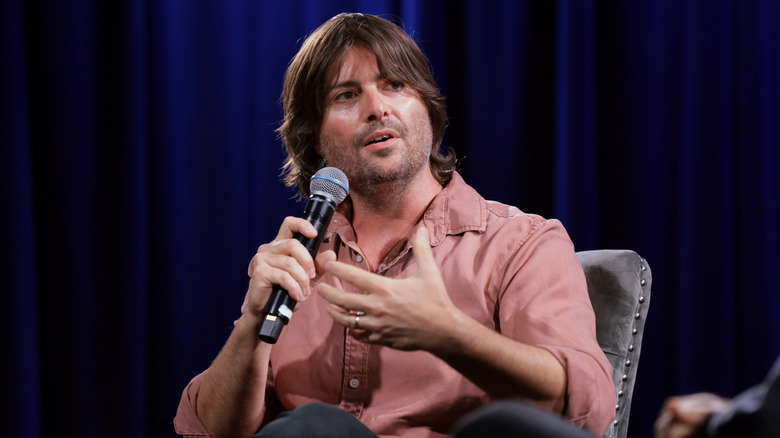 Robert Schwartzman speaking on stage in 2025 in front of a dark blue curtain at the "Megadoc" Q&A