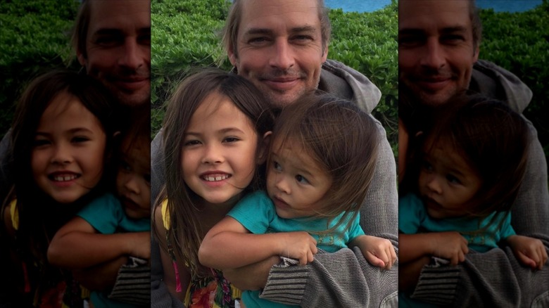 Josh Holloway smiling with his arms around his two children