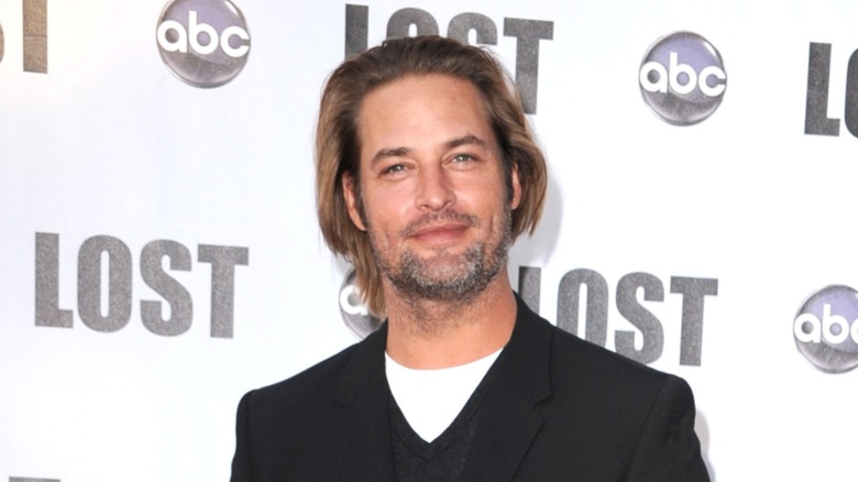 Josh Holloway in front of an ABC and LOST step-and-repeat celebration for the finale