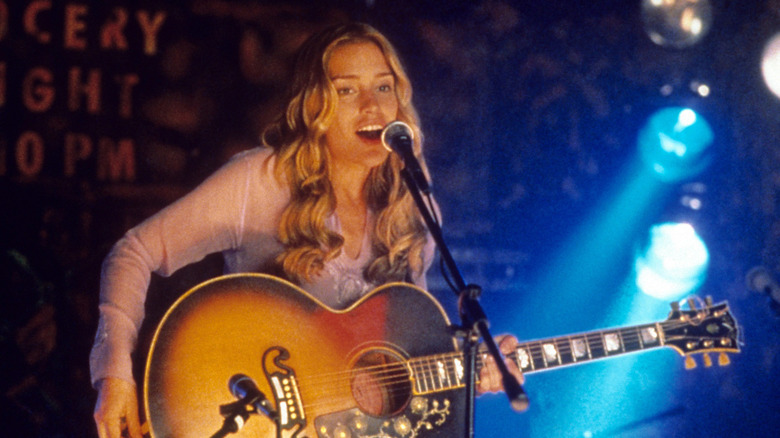 Piper Perabo singing and playing guitar in a scene from Coyote Ugly