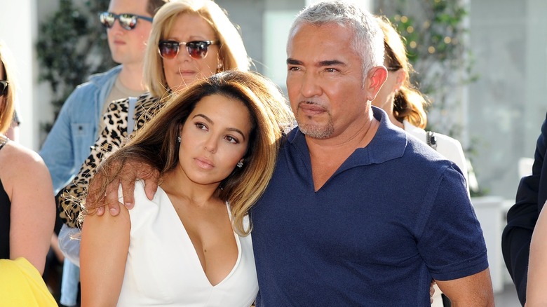 Cesar Millan with his arm around Jahira Dar, who's wearing white